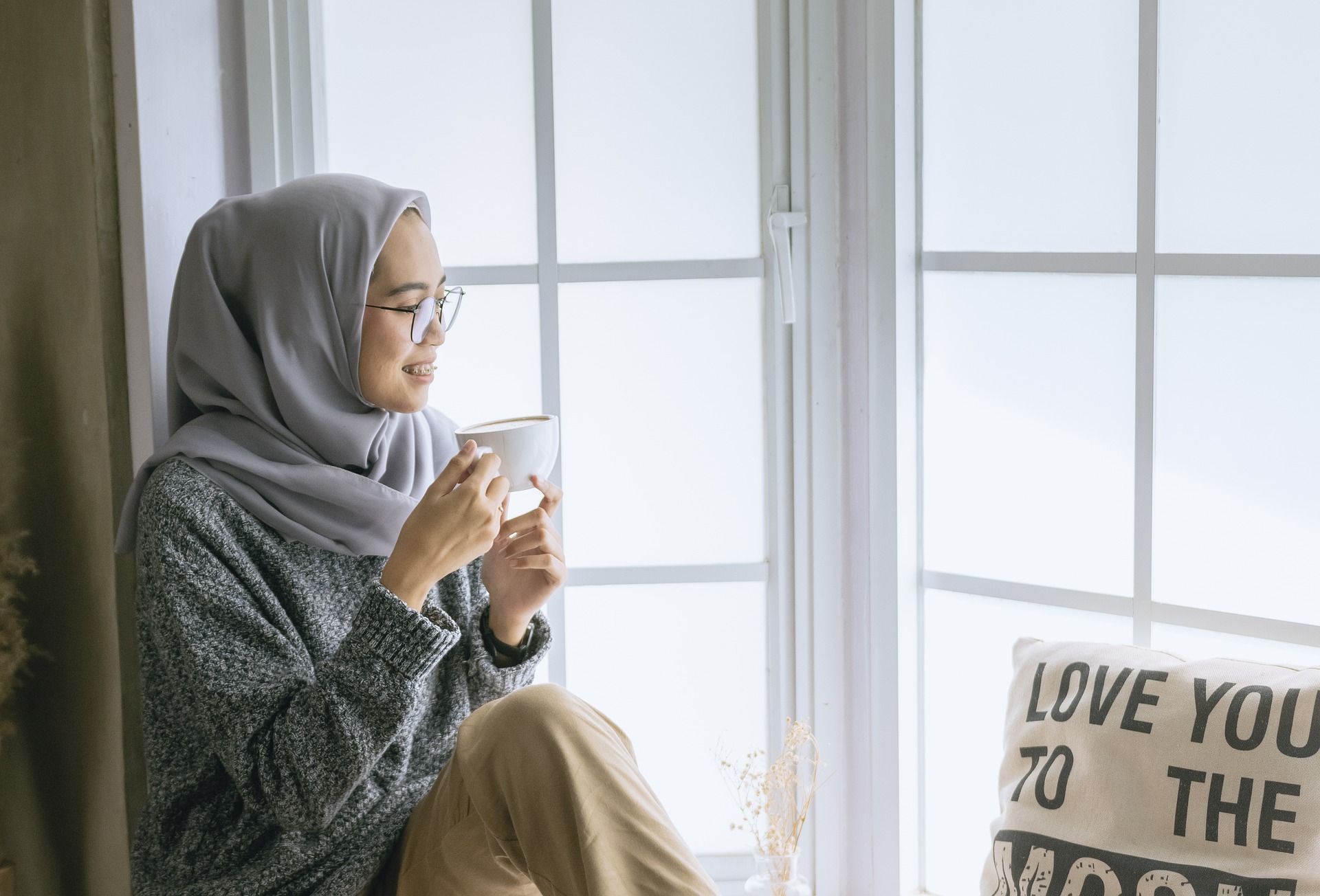 Stile di Vita - Donna affacciata alla finestra che gusta un caffè